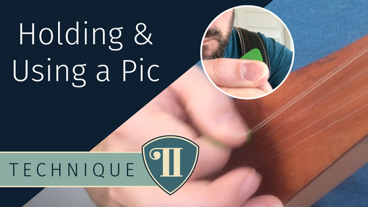 holding and using a pic while a playing stick dulcimer guitar
